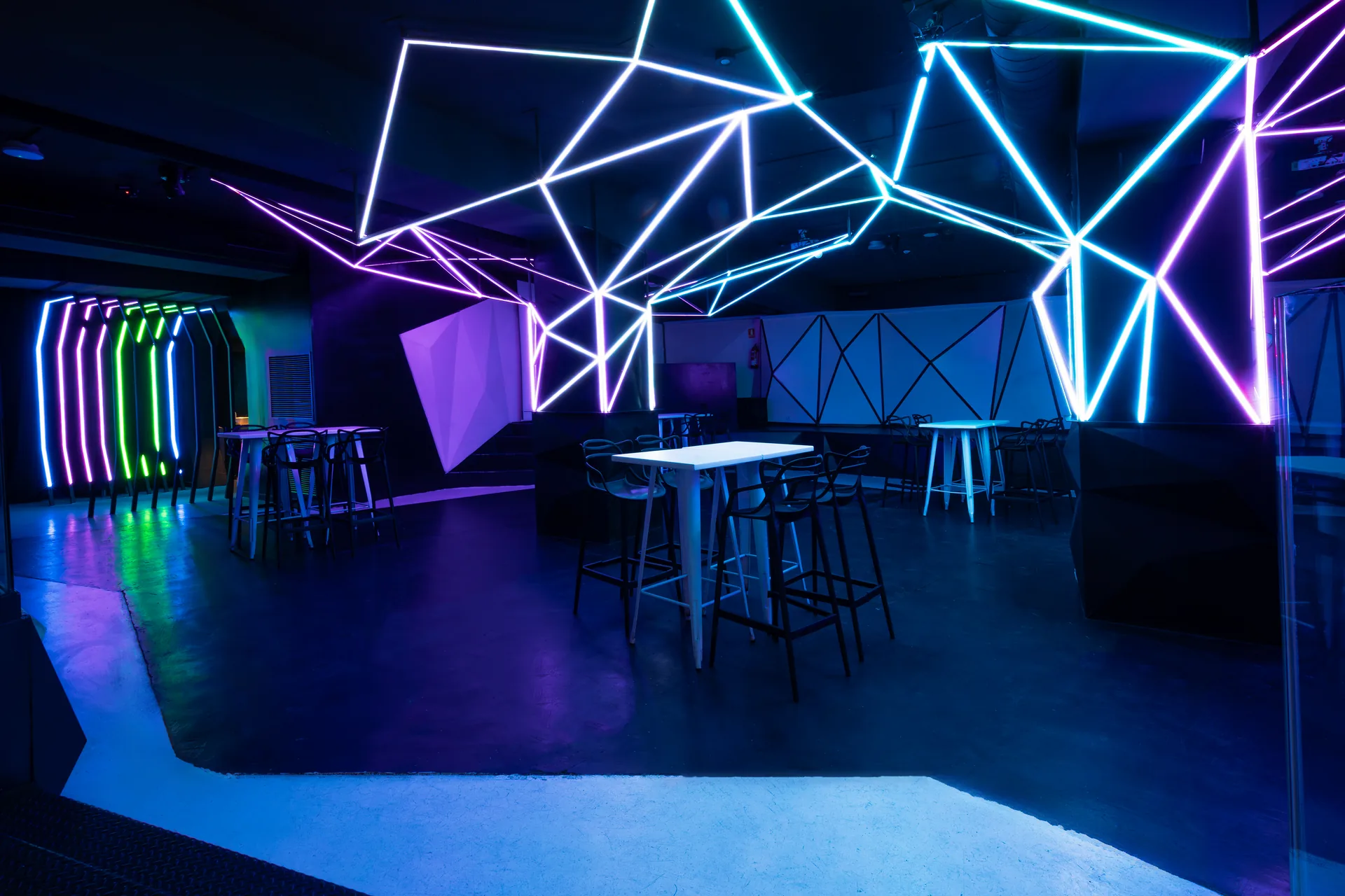 Sala principal con iluminación neon de Showroom Fashion Bar